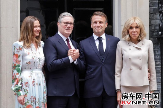 7月9日，英国首相斯塔默（左二）和夫人（左一）在英国伦敦唐宁街10号首相府前迎接法国总统马克龙（右二）和夫人。新华社发